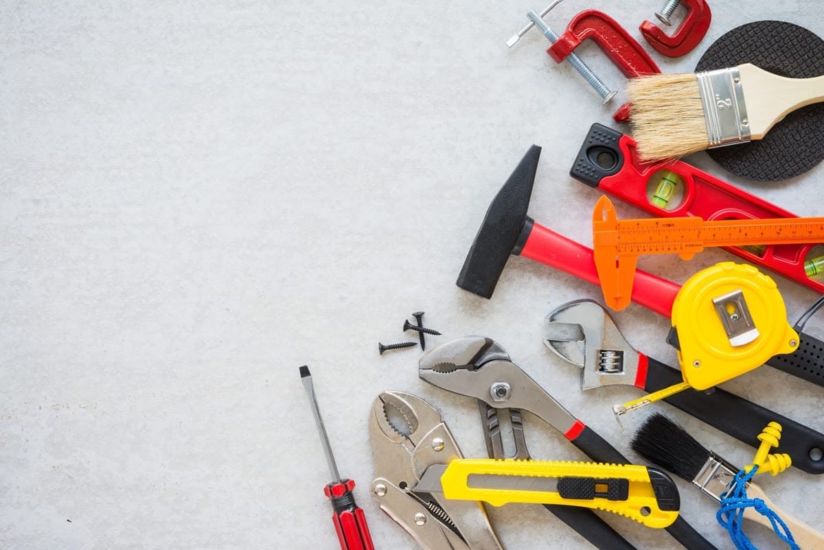 Hand tools, fasteners and measuring gear laid out on a work surface