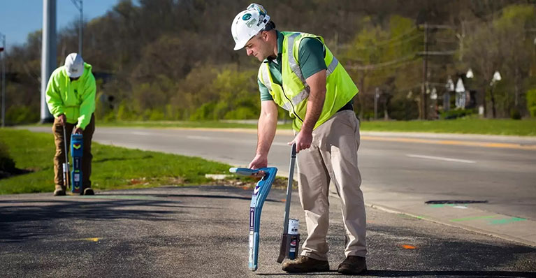 Utility marking crew locating lines on a job site