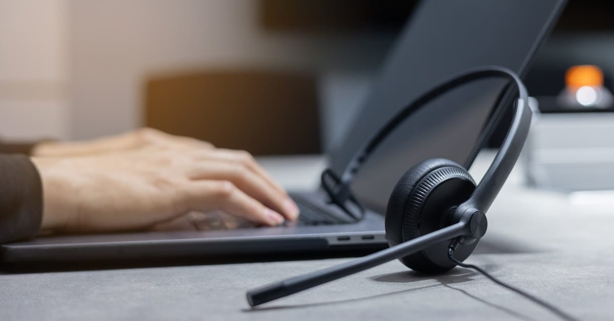 Headset resting beside a laptop as an order is typed up at the service desk